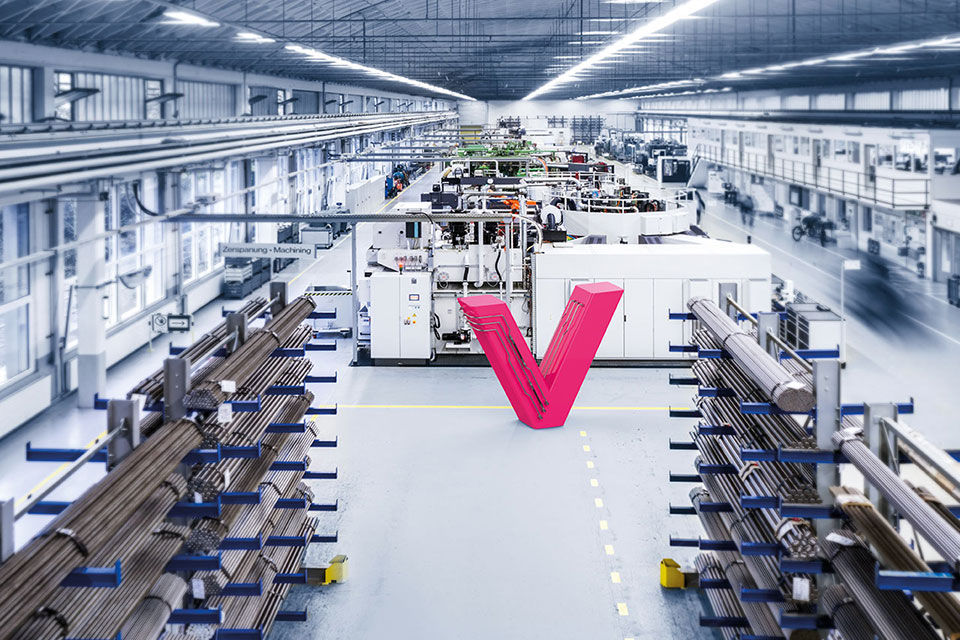 Dieses Bild zeigt ein magentafarbenes 'V' in einer Produktionshalle.